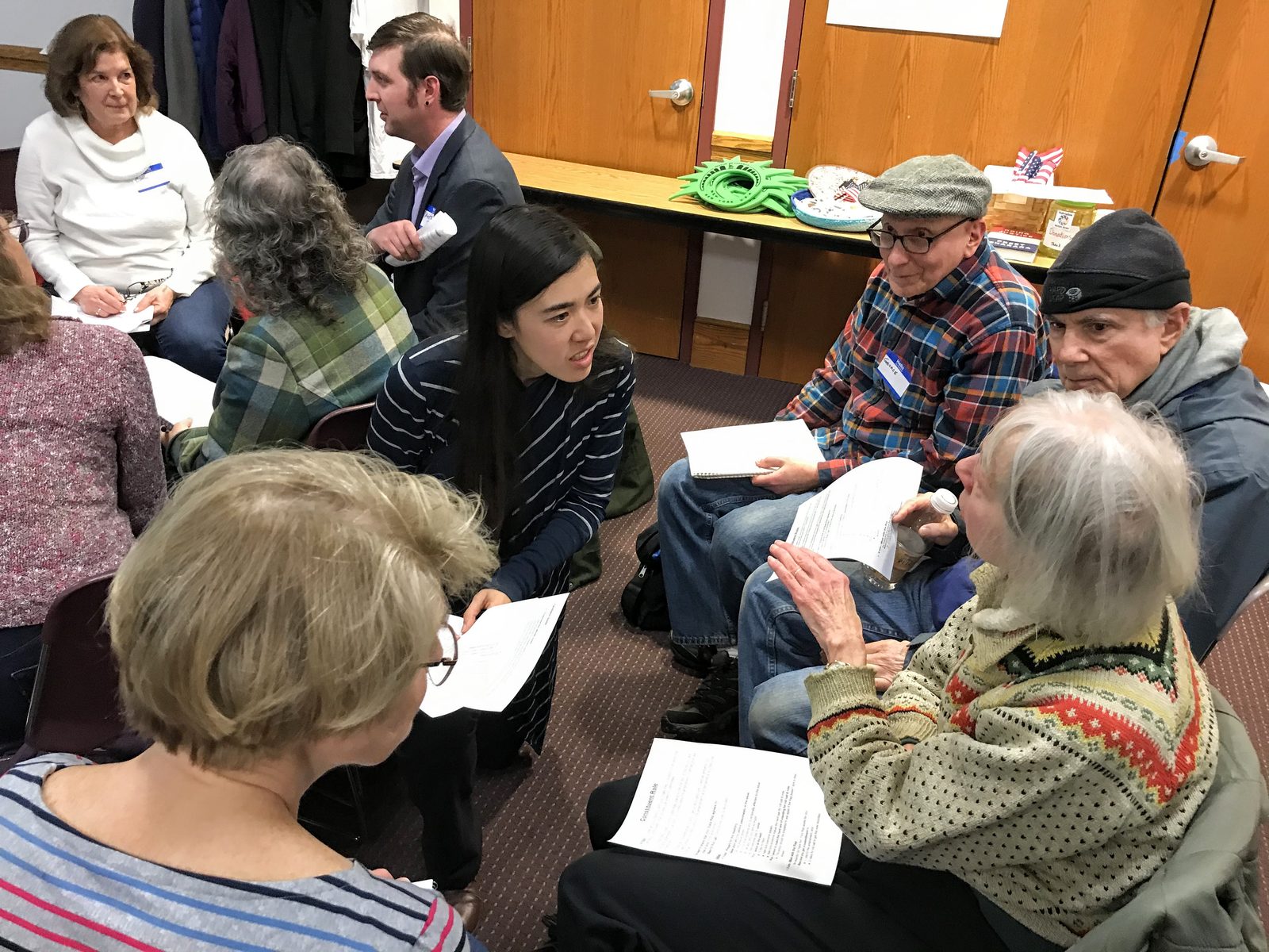 Erika in conversation with neighbors at a community meeting